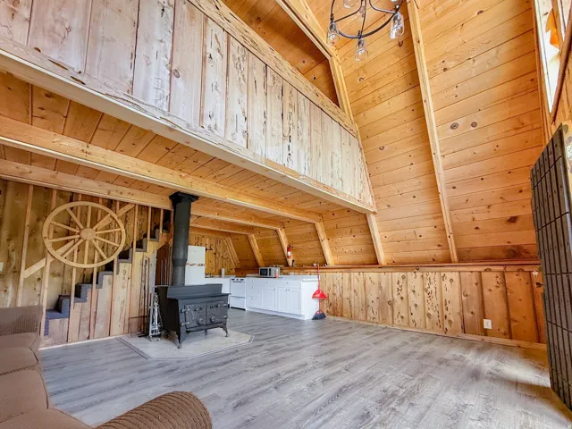 Spacious open-concept interior featuring wood-finish flooring and extensive natural wood paneling