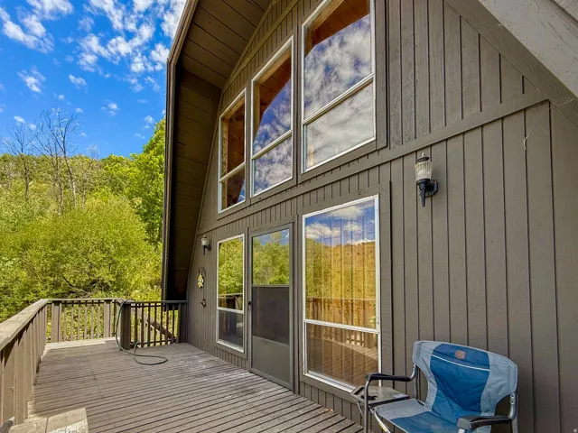 A-frame exterior featuring vertical wood siding and a multi-level deck with a wood railing
