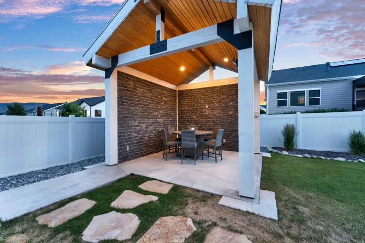Covered patio area featuring a sloped wood-finish ceiling, exposed beams, and recessed lighting