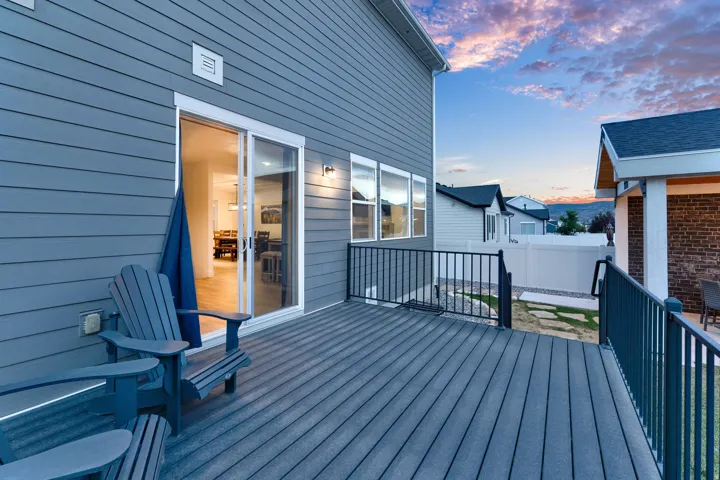 Spacious composite deck with black metal railings, offering an exterior entry point through a sliding glass door