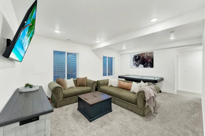 Spacious recreation room featuring recessed lighting, light gray carpeting, and white walls