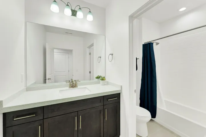 Bathroom featuring a dark wood-finish vanity with ample storage and brushed nickel hardware