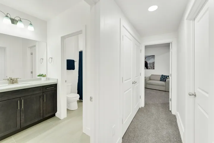 Modern bathroom featuring a dark wood-finish vanity with a light countertop and integrated sink