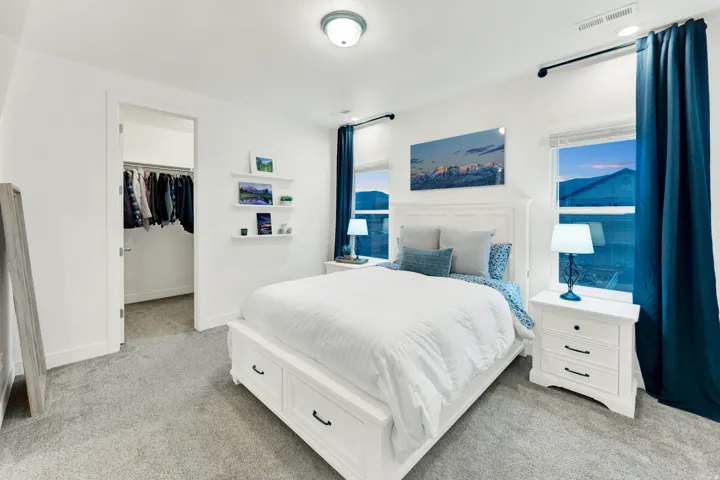 Bright bedroom featuring light gray carpet flooring and white walls