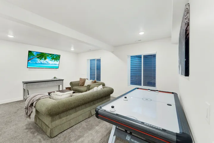 Spacious room with recessed lighting and two windows featuring horizontal blinds