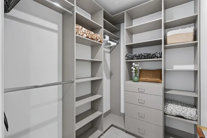 Guest House Custom closet system featuring multiple hanging rods, adjustable shelving, and integrated drawer storage