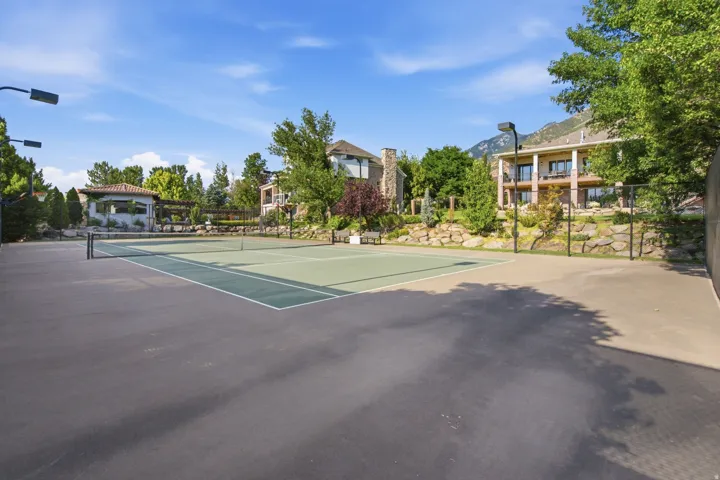 Full-size tennis court featuring a green surface with white line markings