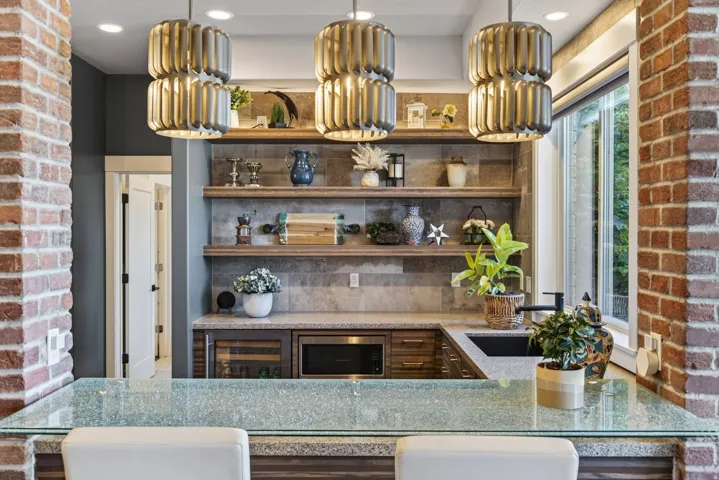 Kitchenette featuring a glass breakfast bar, wood-finish cabinetry, built-in beverage cooler, and under-cabinet microwave