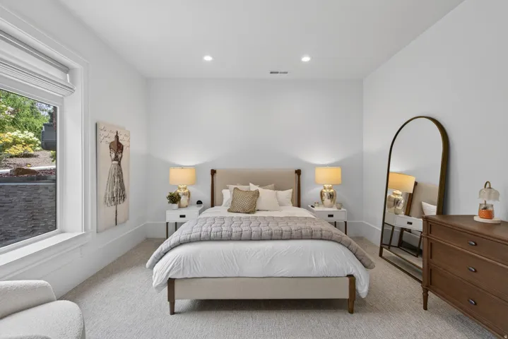 Guest House Spacious room featuring light-toned carpeting, recessed lighting, and a large window with white trim