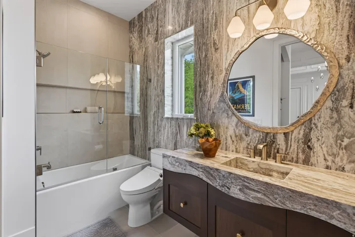 Guest House Bathroom featuring a custom floating vanity with a natural edge countertop and integrated sink