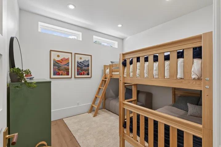 Guest House Bright room with wood-finish flooring, featuring recessed ceiling lighting and high transom windows
