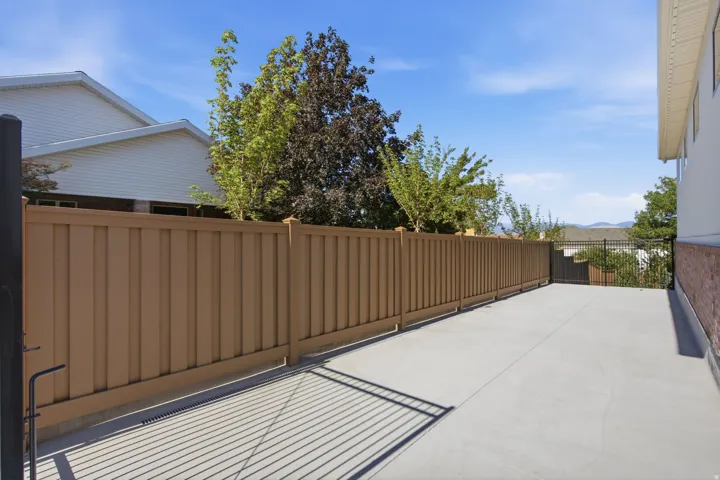 Expansive concrete pad bordered by a tall privacy fence