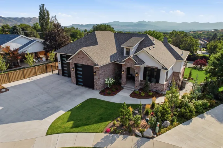 Guest House Contemporary residence featuring a brick and white siding exterior, dark framed windows, and a multi-car garage with modern doors