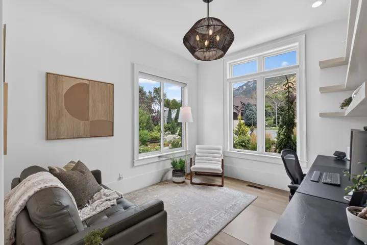 Guest House Bright room featuring large windows, wood-finish flooring, recessed lighting, and a contemporary chandelier