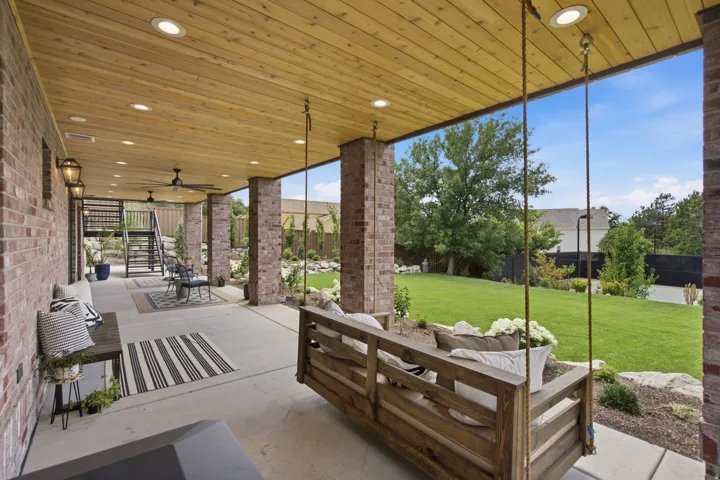 Guest House Expansive covered patio featuring a wood-panel ceiling, recessed lighting, and brick columns