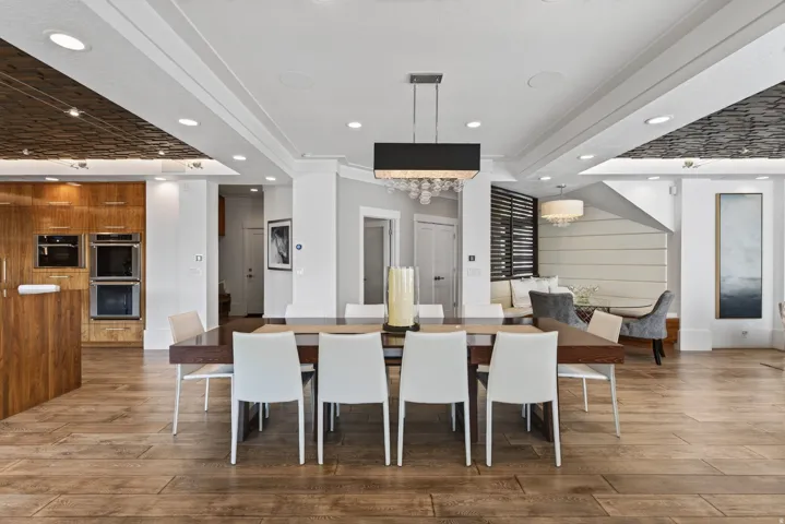 Open-concept dining and kitchen area featuring wood-finish flooring