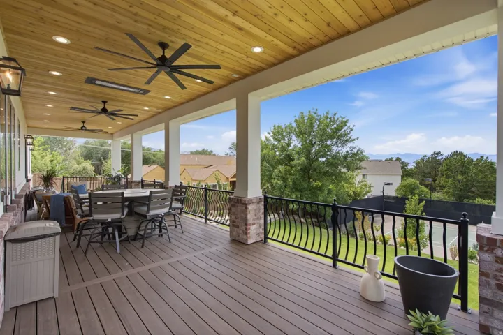 Guest House Spacious covered deck featuring composite decking, a wood-plank ceiling with recessed lighting, and multiple ceiling fans