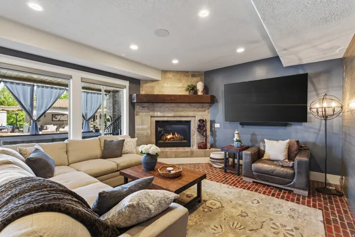 Living area featuring a stone-clad fireplace with a wood mantel, a built-in firebox, and recessed lighting