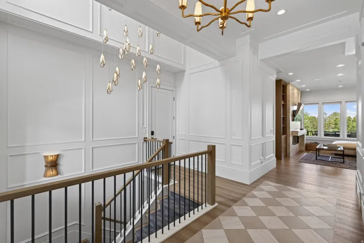 Guest House Two-story foyer featuring wainscoting, a contemporary multi-pendant light fixture, and diamond-patterned tile flooring
