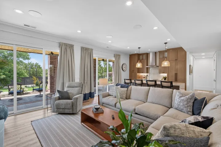 Guest House Open-concept living area featuring wood-finish flooring, recessed lighting, and large sliding glass doors