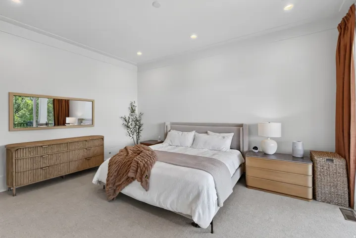 Guest House Recessed lighting illuminates a spacious room featuring crown molding and light-toned carpeting