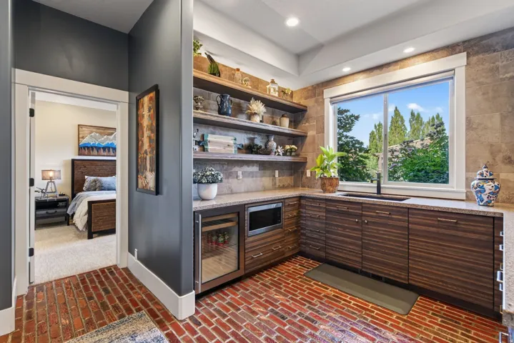 Wet bar featuring wood-finish cabinetry, stone countertops, and a built-in beverage refrigerator