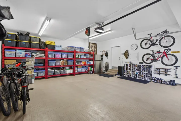Guest House Spacious garage featuring light-toned flooring, white walls, and built-in overhead lighting