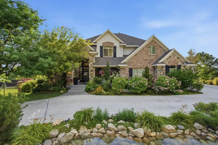 Stone and brick exterior with stucco accents, gabled rooflines, and dark shutters