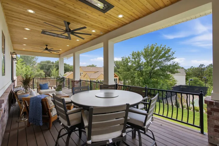 Guest House Expansive covered deck featuring wood-finish flooring, a planked wood-finish ceiling, and integrated recessed lighting