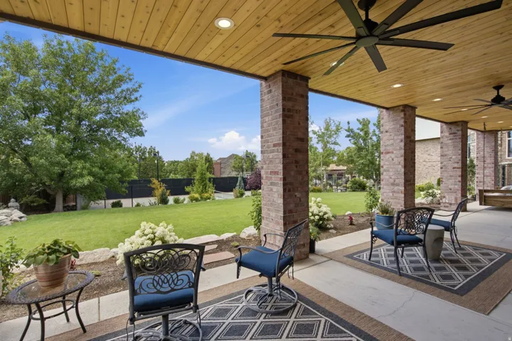 Guest House Expansive covered patio featuring brick columns and a wood-finish ceiling with recessed lighting