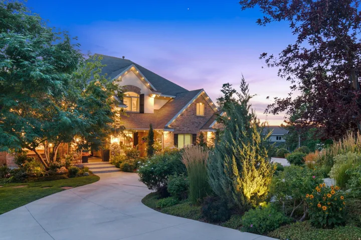 Stately residence featuring a brick and stucco exterior, dark shingle roofing, and decorative shutters