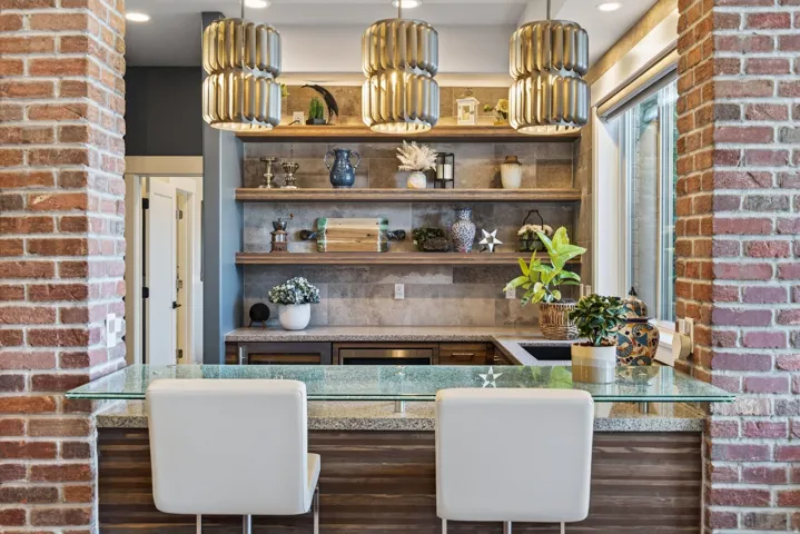 Wet bar featuring a granite countertop, wood-finish cabinetry, and open shelving