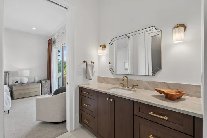 Guest House Vanity featuring a stone countertop, undermount sink, and brass-finish fixtures