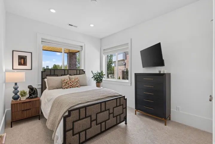 Guest House Bright bedroom featuring two windows, recessed lighting, and soft carpet flooring
