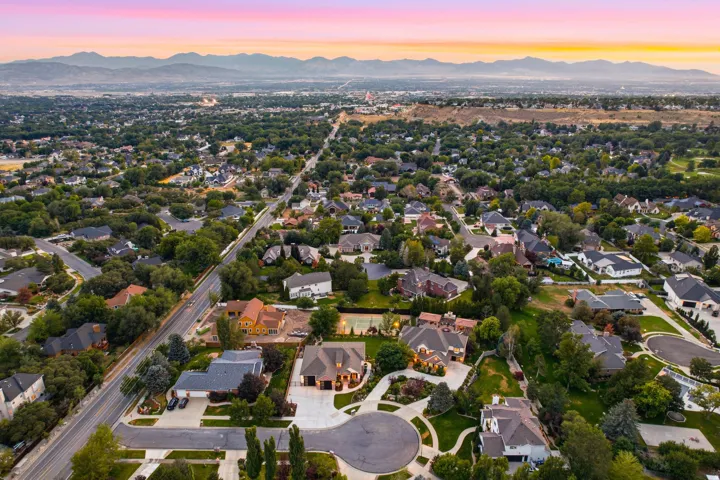 Expansive residential area featuring numerous single-family homes, mature trees, and a distant mountain range