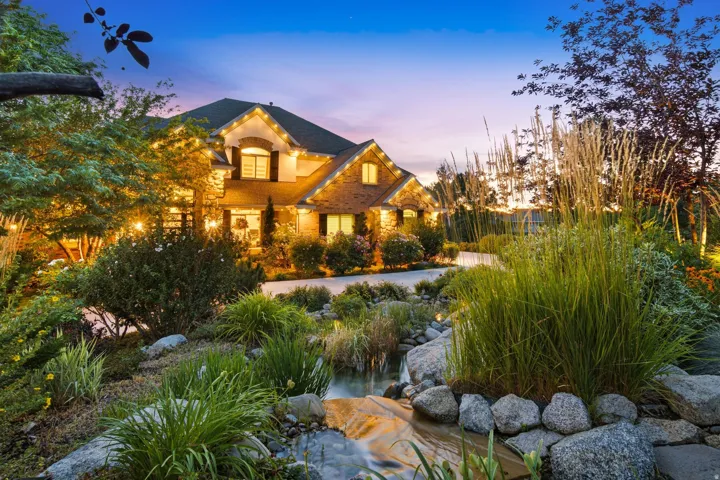 Elegant brick facade residence featuring a dark roof, arched windows, and decorative shutters