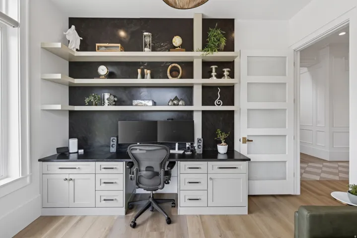 Guest House Custom built-in desk with extensive cabinetry and dark countertops