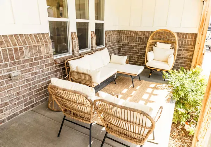 Covered outdoor patio featuring a brick facade and concrete flooring