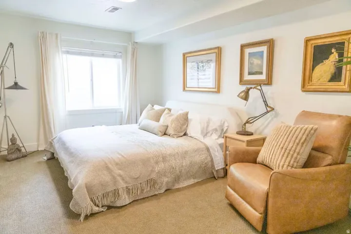 Carpeted bedroom with a large window and neutral wall tones