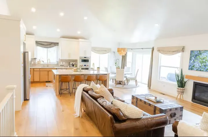 Open concept living space featuring wood-finish flooring, vaulted ceilings, and recessed lighting