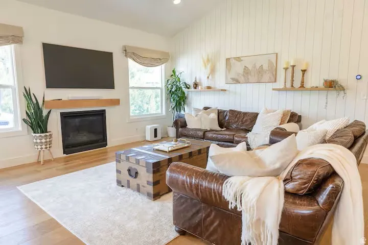 Living area with a fireplace, a wood-finish mantel, and two large windows