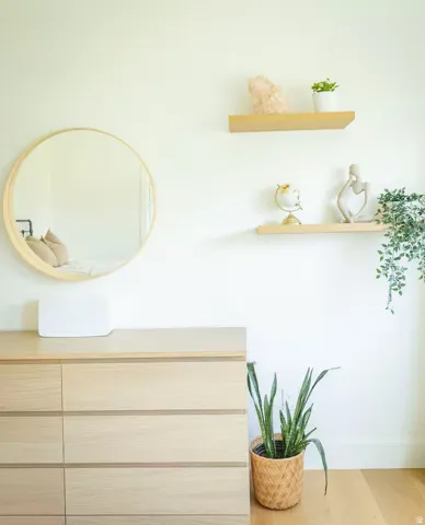Light wood-finish dresser with six drawers, complemented by a round framed mirror