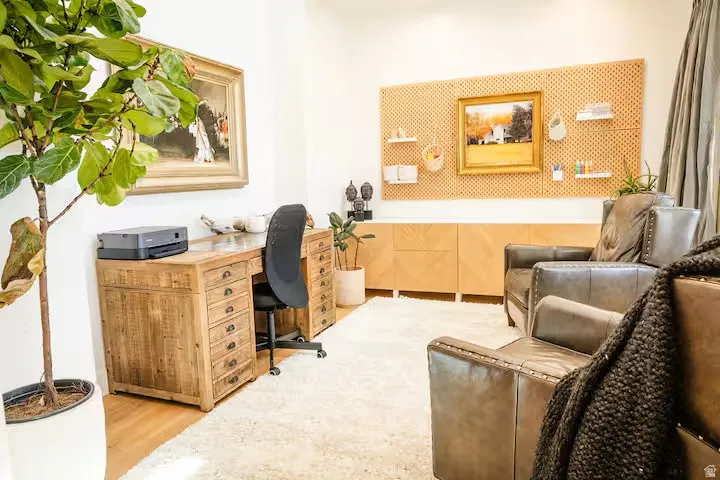 Dedicated office space featuring a light wood-finish desk with multiple drawers