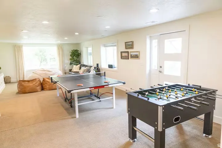 Spacious room featuring neutral carpeting, recessed lighting, and multiple windows providing ample natural light