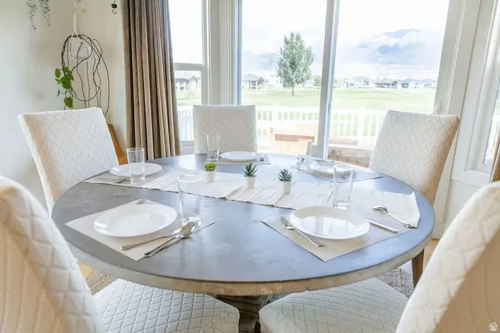 Dining area featuring a round table, perimeter windows, and outdoor scenery