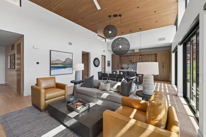 Open-concept living space with a wood-finish ceiling, light wood-finish flooring, and high ceilings