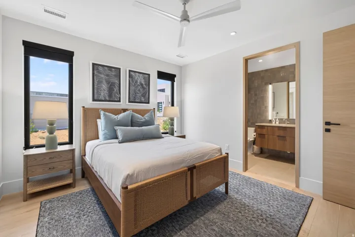 Light wood-finish flooring with an area rug, white walls, and recessed lighting