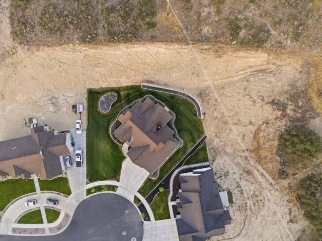 New construction home featuring a brown shingle roof, green lawn, and a large concrete driveway