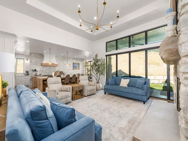 Open-concept living area with a vaulted ceiling and a contemporary chandelier