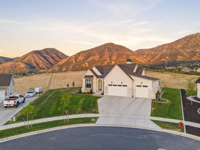 Contemporary residence with a multi-car garage, manicured lawn, and a stone facade accent
